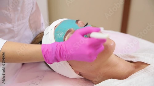 Spa Woman applying Facial cleansing Mask.