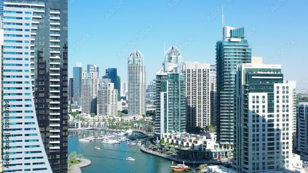 Aerial view of Dubai city. Drone fly over futuristic Dubai Marina district on beautiful day. Residential Modern skyscraper buildings, Jumeirah Beach, UAE, Middle East smart city