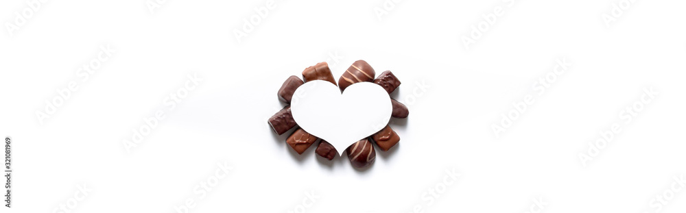 on a white background under a white heart a gift for Valentine's Day tasty different chocolates in the form of postcards with copy space