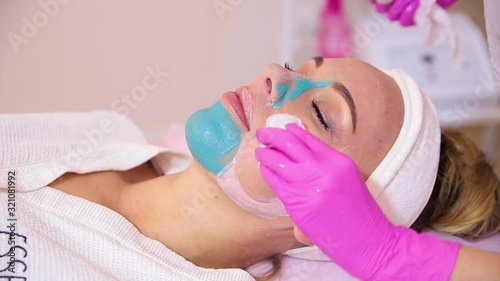 Spa Woman applying Facial cleansing Mask.