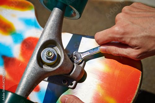 A man customizing skateboard outdoor 