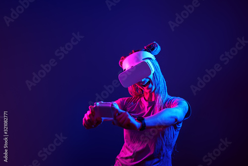 Woman is using virtual reality headset. Neon light studio portrait. © nuclear_lily