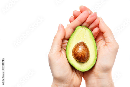 Avocado in female hand on white background