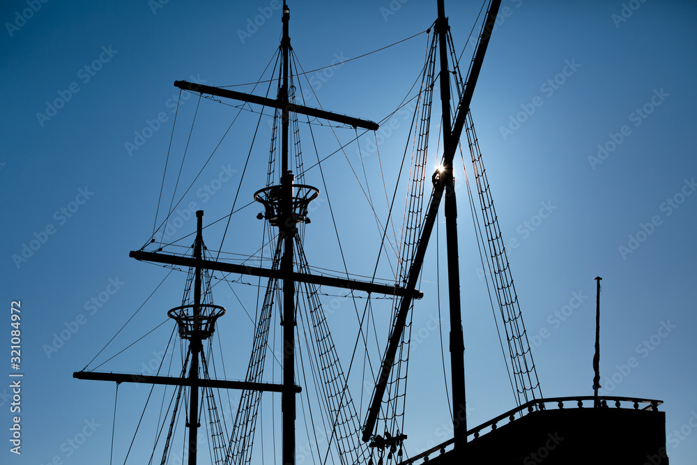 Sailing masts of an antique ship on blue sky background Sailing masts of an antique ship on blue sky background