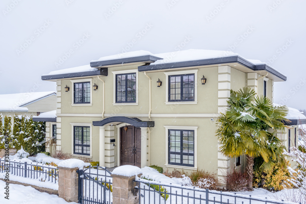 A heavy snowfall. The typical american house in winter. Snow covered.