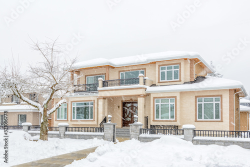 A heavy snowfall. The typical american house in winter. Snow covered.