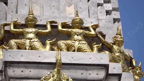 Golden Figures Ornaments on Stupa of Buddhist Temple Complex in Bangkok, Thailand, Close Up Pan photo