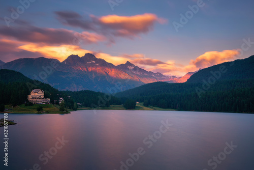 Sunset above lake St. Moritzersee with Swiss Alps and a mountain hotel