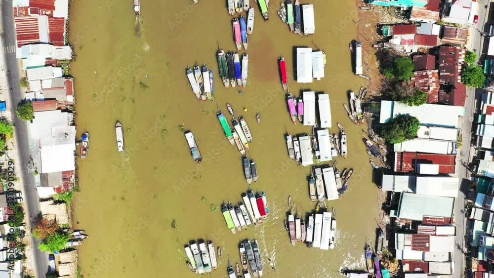 Vue à haute altitude du marché flottant de Cai Rang où les habitants locaux échangent des marchandises ainsi que quelques bâtiments bordant le marché, vers Can Tho, au Vietnam