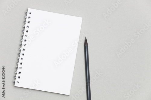 Blank notebook or notebook with pencil on gray desk background. 