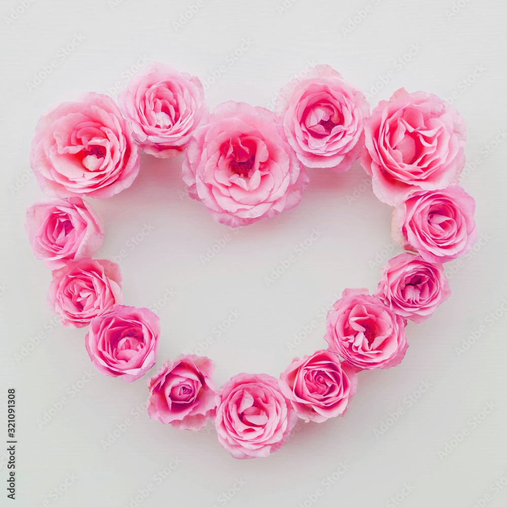 Heart frame made of fresh pink roses in full bloom on white wooden background, top view. Heart frame made of fresh pink roses in full bloom on white wooden background, top view.