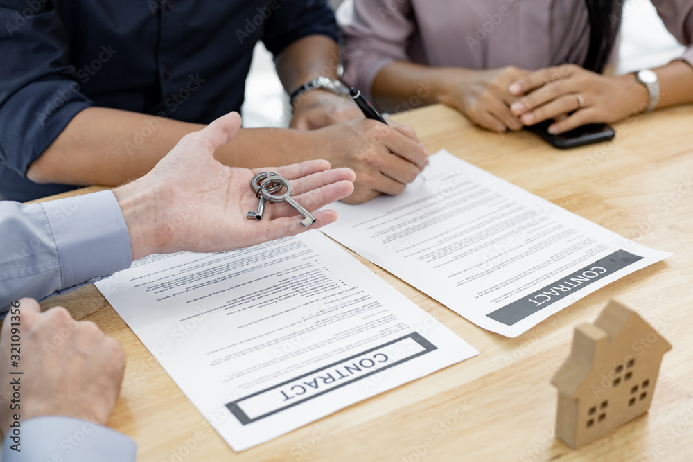 Couple completes the house purchase contract and the broker gives the house key. Couple completes the house purchase contract and the broker gives the house key.