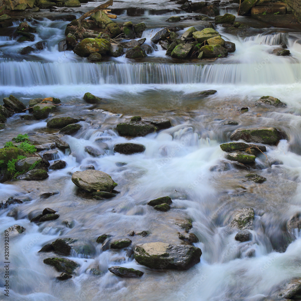 West Lyn River in village of Lynmouth, Devon, on the northern edge of Exmoor National Park. Long exposure of the river flows downstream. West Lyn River in village of Lynmouth, Devon, on the northern edge of Exmoor National Park. Long exposure of the river flows downstream.