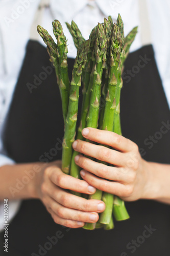 woman holding a green asparagus in her hands