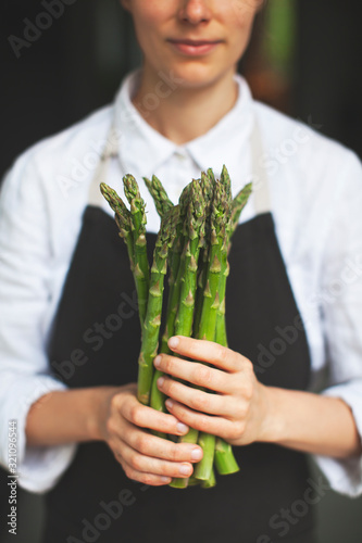 woman holding a green asparagus in her hands