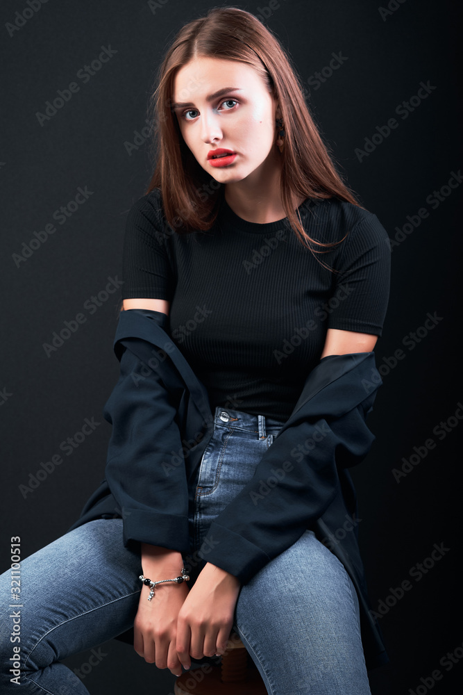 Young beautiful girl posing in studio dressed in a black jacket. Young beautiful girl posing in studio dressed in a black jacket.