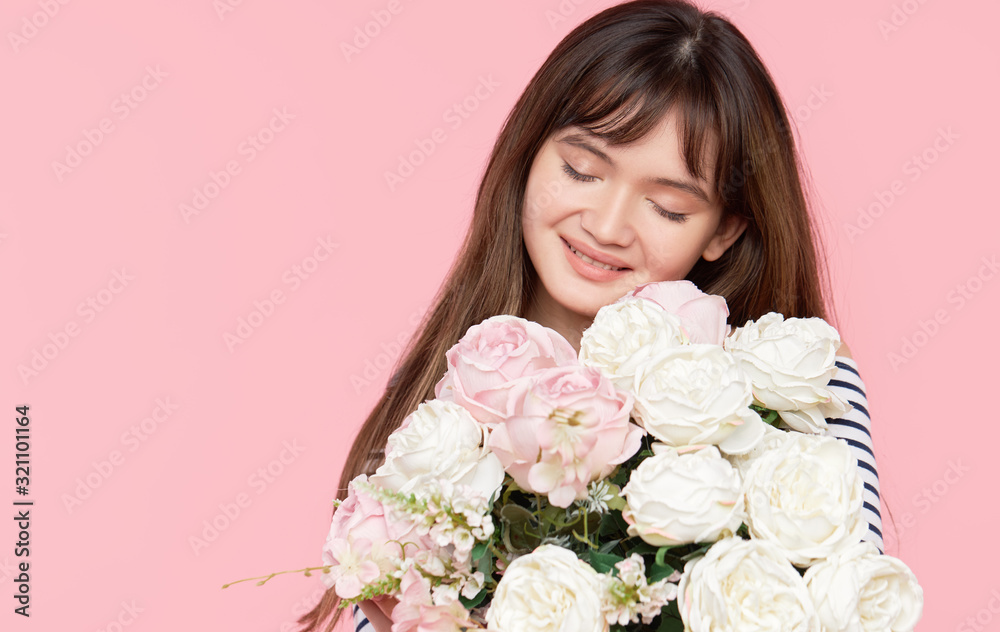 Beautiful Asian girl holds a beautiful lush bouquet in her hands on a light background