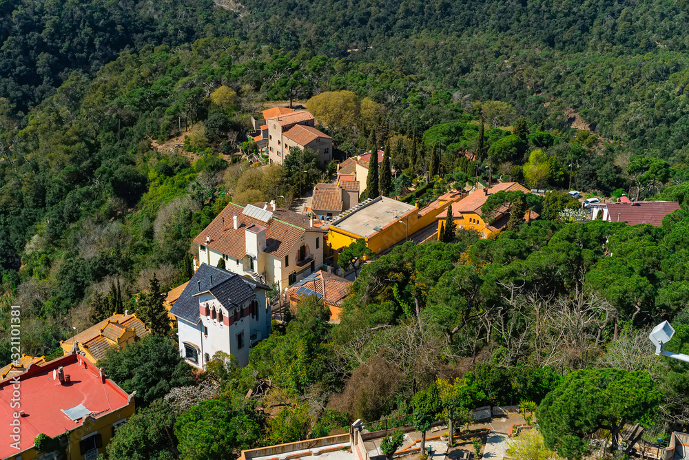 Stone houses on the hill surrounded with trees. Small vilage near Barcelona, Spain