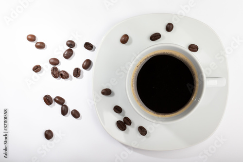 White cup with coffee on a white background and coffee beans