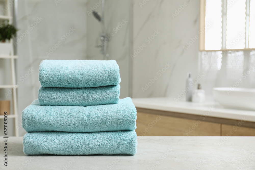 Stack of clean towels on table indoors. Space for text Stack of clean towels on table indoors. Space for text