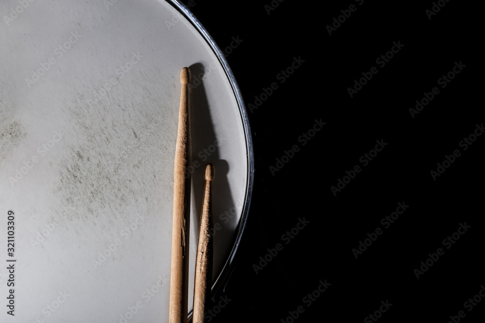 Drum stick and drum on black table background, top view, music concept Drum stick and drum on black table background, top view, music concept
