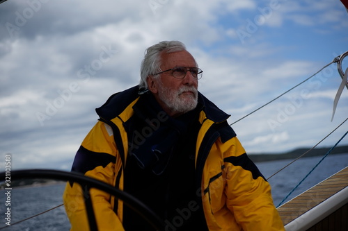 White bearded sailing senior, experienced skipper on a sailboat