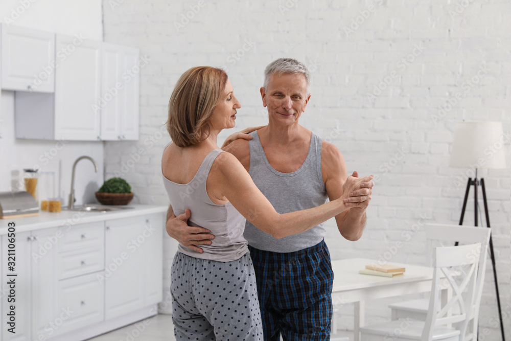 Happy senior couple dancing together in kitchen Happy senior couple dancing together in kitchen