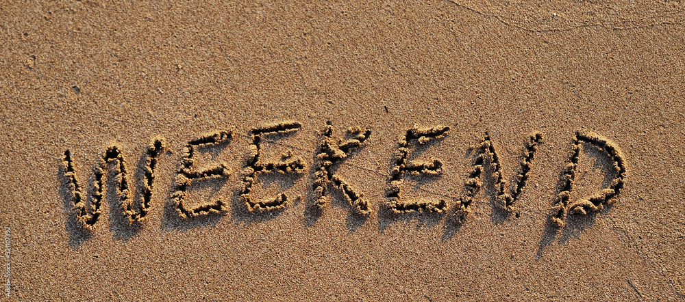 Fototapeta premium Weekend written on sand.