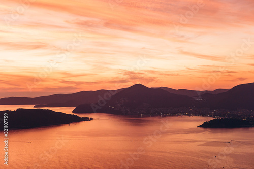 Beautiful view of the sunset and the natural landscape with the sea and hills or mountains in Montenegro.