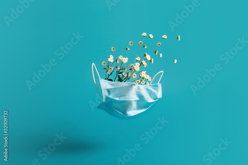 Medical blue mask with flowers. Creative concept of seasonal flu and allergies.