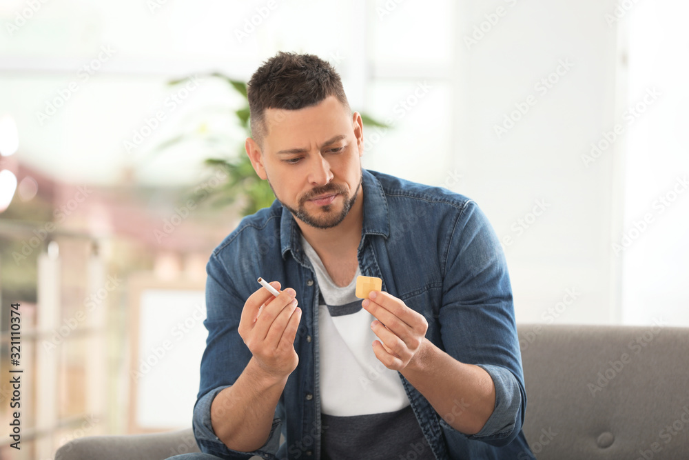 Фотография Man with nicotine patch and cigarette at home