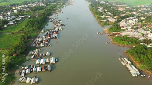 La rivière Bassac, le village flottant de Chau Doc et des rizières en arrière plan éclairés au coucher du Soleil dans le delta du Mékong, au sud du Vietnam photo