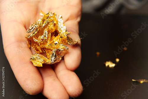 Canvas Print Artwork of gilding - sheet of creased gold metal plate in hands