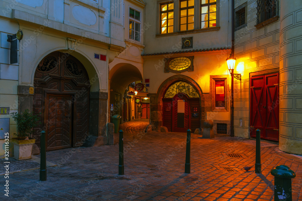 Obraz premium Narrow night streets lit by old lanterns in the center of Prague