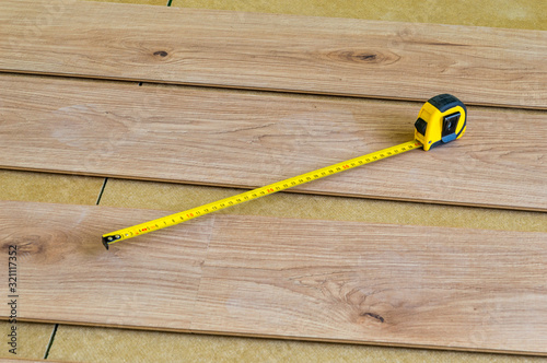 Tape measure on floor panels when laying them on the floor. photo