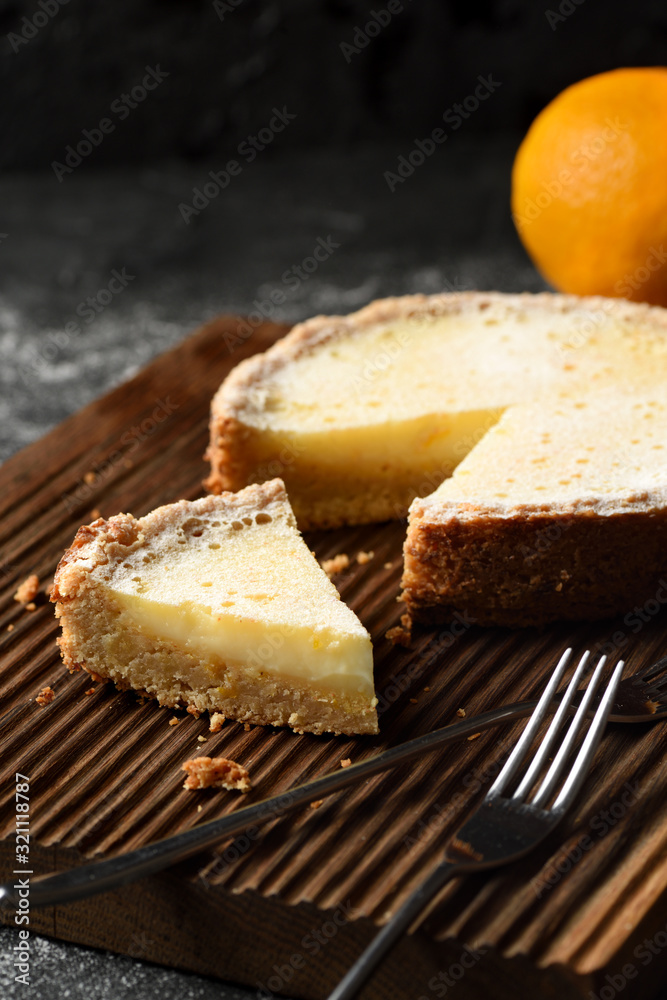 Healthy wholegrain crust gluten free lemon pie on oak board on black background high angle view