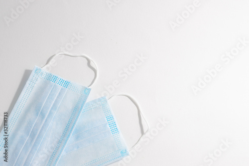 Two sterile medical masks on white background with copy space for your text. Epidemic diseases prevention concept. Minimal style composition. Flu season concept.