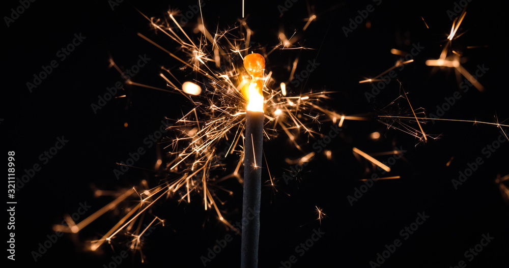 Firework festive sparkler burning on black background