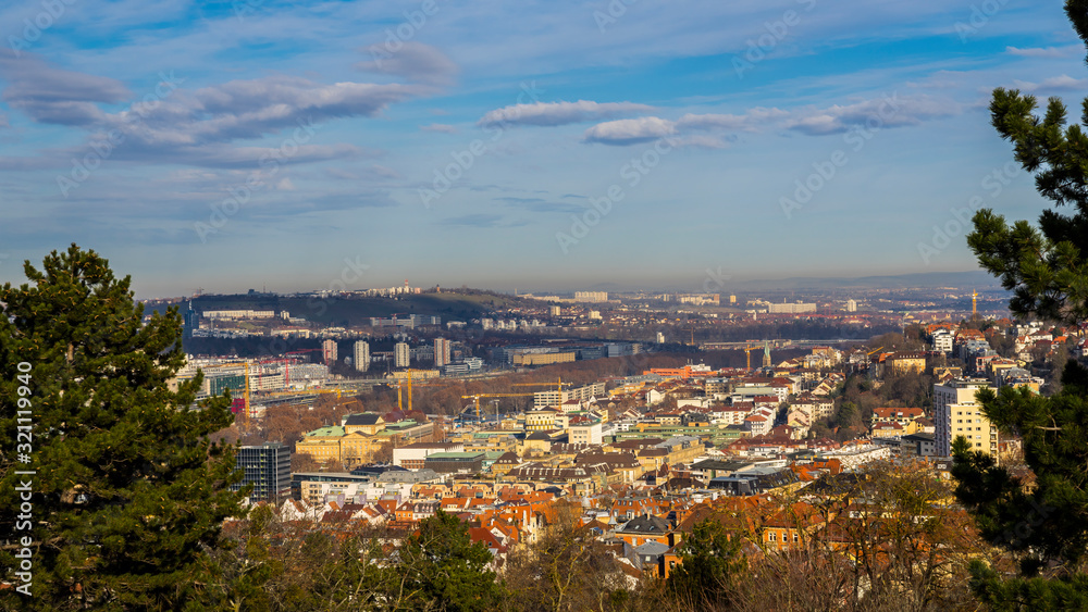 Germany, Aerial view above stuttgart downtown houses, cranes and skyline in valley with sun and clouds