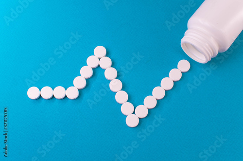 pulse laid out from white tablets and packing from them on a blue background.