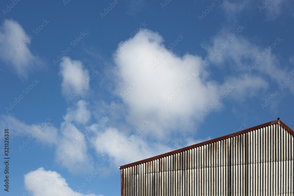 corner of a building with clouds in the background