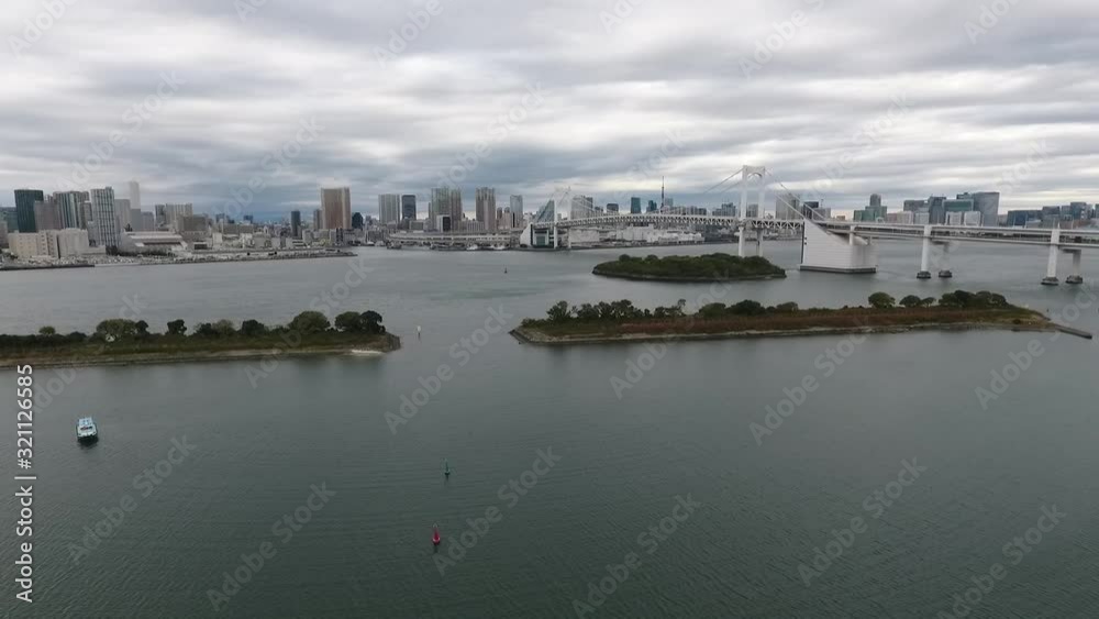 Tokyo - Fly side of Rainbow bridge with skyline in back on windy day - Aerial Tokyo - Fly side of Rainbow bridge with skyline in back on windy day - Aerial