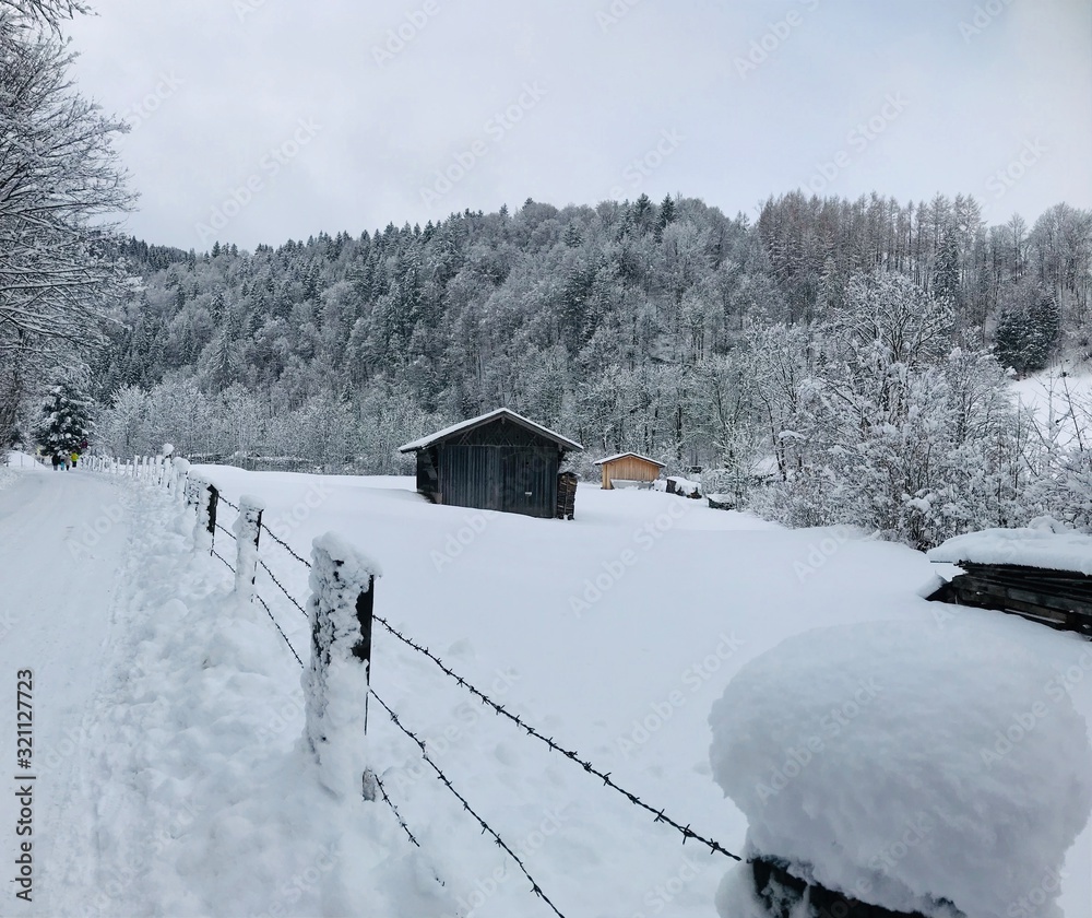Einsames Haus auf unberührer verschneiter Schneelandschaft vor Wald