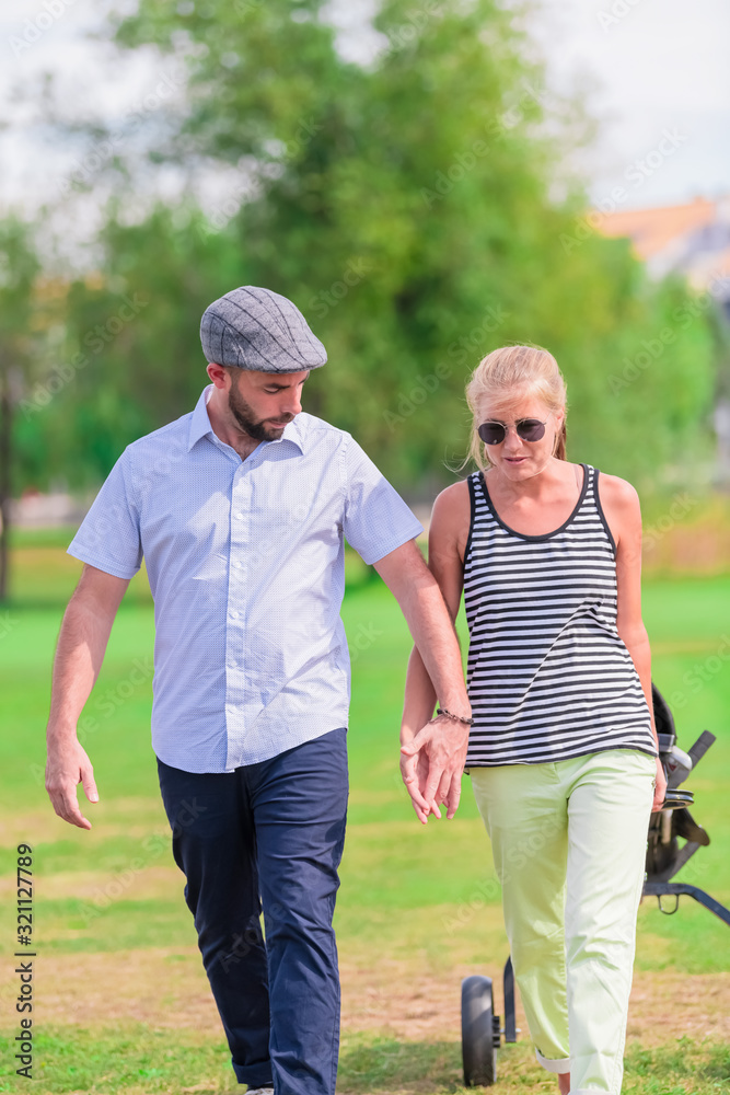 Couple hold hands while having a walk at the park
