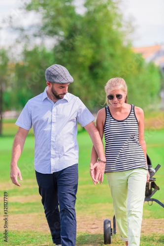 Couple hold hands while having a walk at the park © JeanPaul