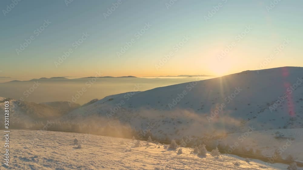 Sunrise at misty snowy mountain peaks in serene panoramic view Sunrise at misty snowy mountain peaks in serene panoramic view