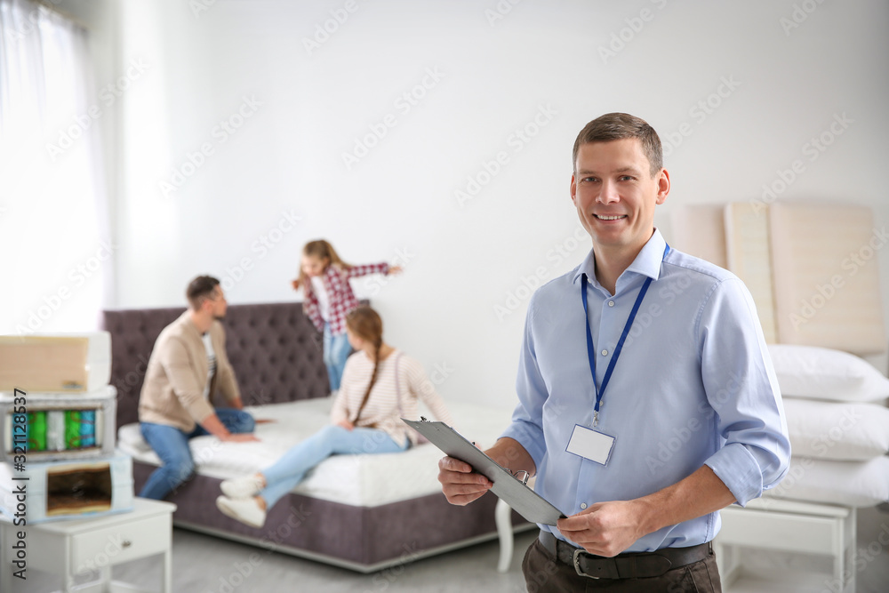 Happy salesman and his clients in mattress store Happy salesman and his clients in mattress store