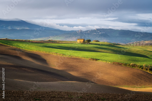 Amazing spring landscape with green rolling hills and farm houses in the heart of Tuscany in morning