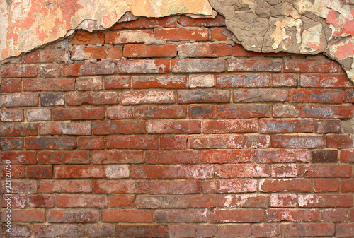  An average plan of an old red weathered brick wall with cement remains