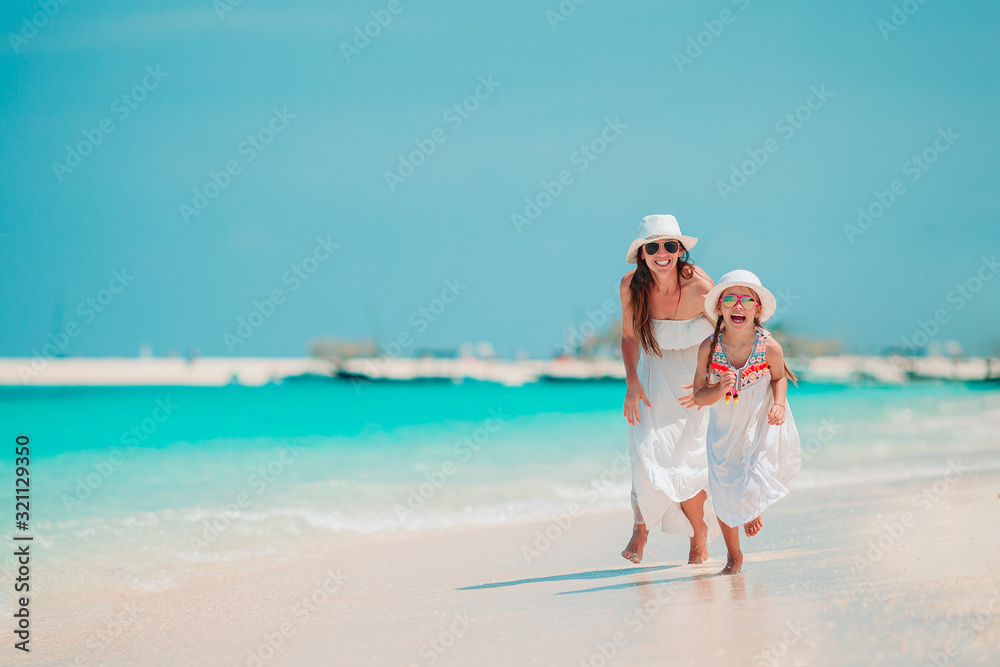 Beautiful mother and daughter at Caribbean beach enjoying summer vacation. Beautiful mother and daughter at Caribbean beach enjoying summer vacation.